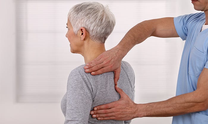 Ältere Frau bei der Behandlung durch Osteopathen