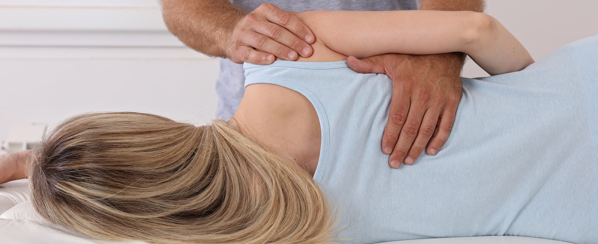 Frau auf Liege bei der Behandlung von Schulterschmerzen